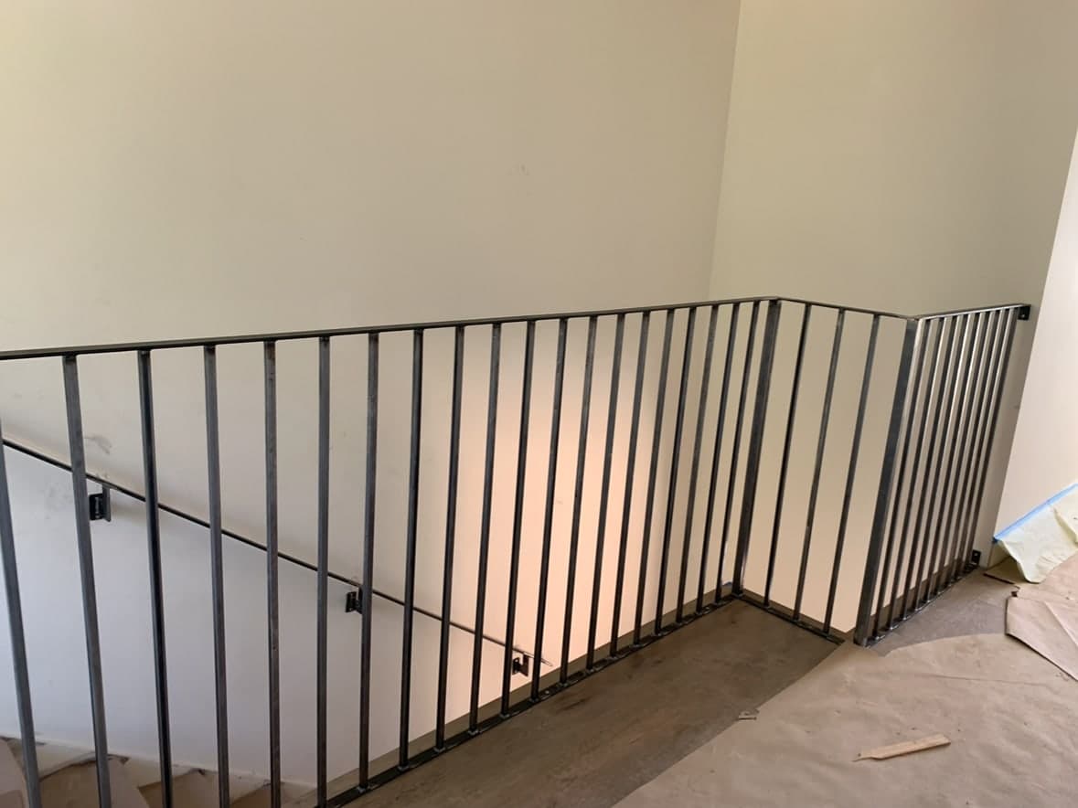 Black interior stair railing with straight balusters.