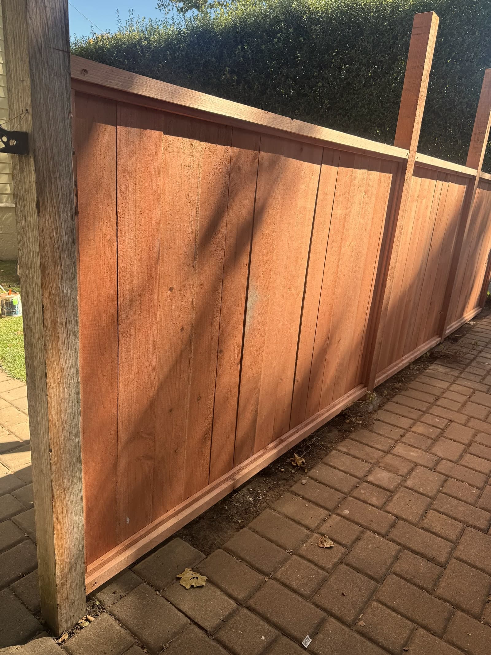 Close view of redwood fence boards and trim detail.